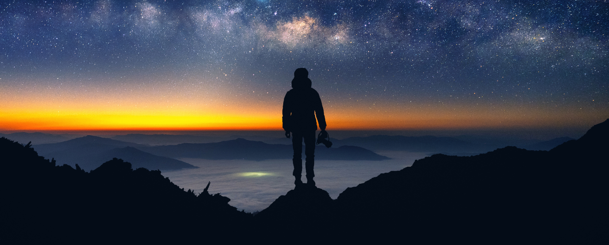 Silhouette d'un explorateur devant un ciel étoilé